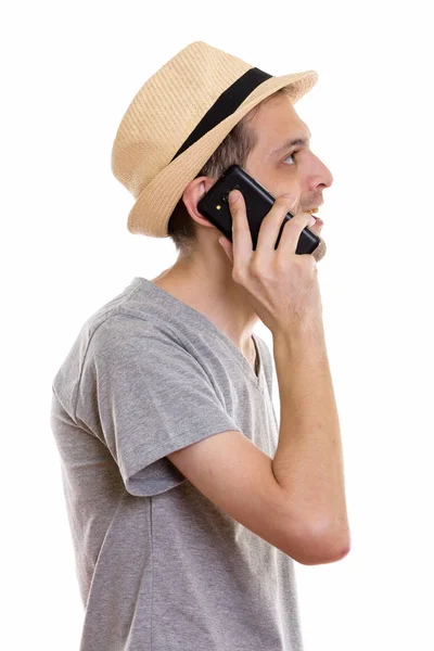 Widok profilu szczęśliwy młody człowiek uśmiechający się podczas rozmowy na telefonie — Zdjęcie stockowe
