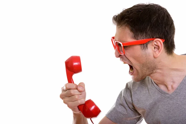 Close up de jovem irritado gritando ao telefone velho — Fotografia de Stock