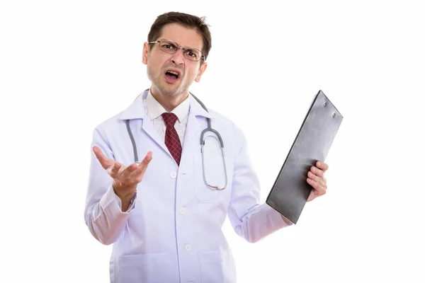 Studioaufnahme eines wütenden jungen Mannes Arzt hält Klemmbrett mit Arm — Stockfoto