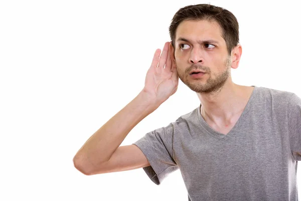 Studio shot of young man listening — Stock Photo, Image