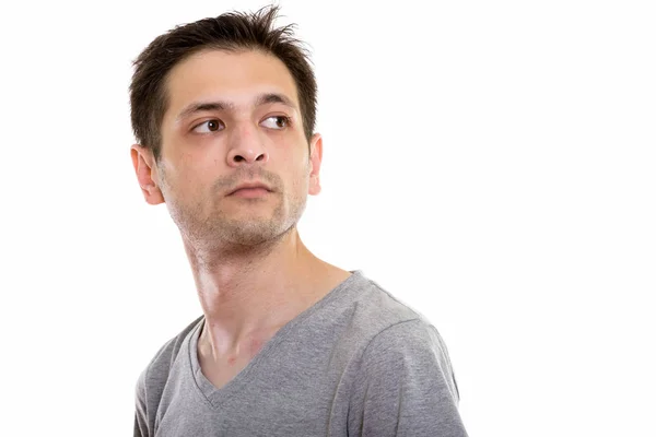 Studio shot of young man looking back while thinking — Stock Photo, Image