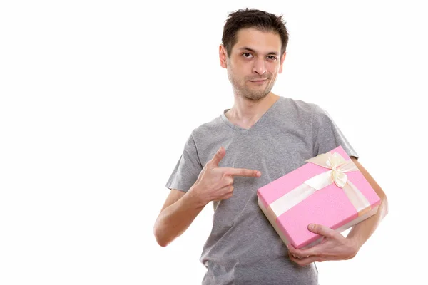 Studio colpo di giovane uomo in possesso e indicando scatola regalo pronto — Foto Stock