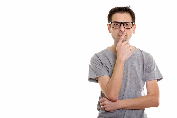 Studio shot van jonge man denken terwijl het dragen van bril — Stockfoto