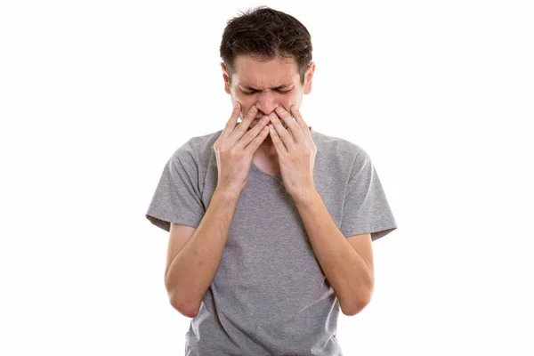 Estúdio tiro de jovem estressado olhando cansado ao cobrir f — Fotografia de Stock