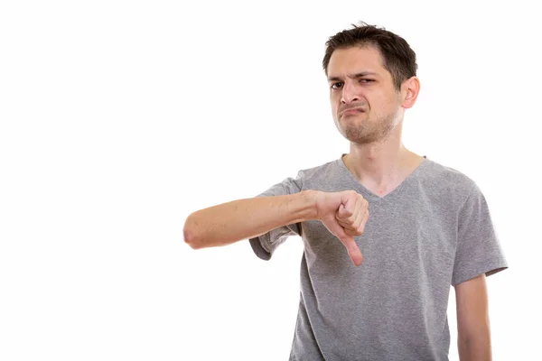 Studio shot of young man giving thumb down — Stock Photo, Image