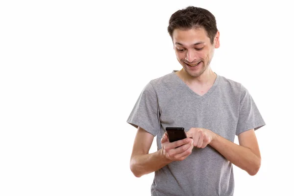 Studio colpo di felice giovane uomo sorridente durante l'utilizzo del telefono cellulare — Foto Stock