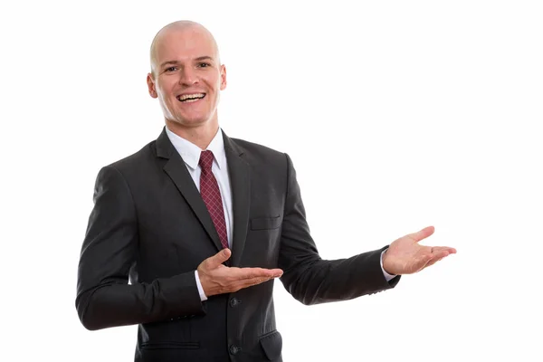 Studioaufnahme eines jungen, glücklichen, glatzköpfigen Geschäftsmannes, der während der Show lächelt — Stockfoto