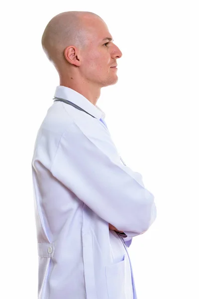 Widok profilu lekarza młody przystojny łysy mężczyzna z ramionami skrzyżowanymi — Zdjęcie stockowe
