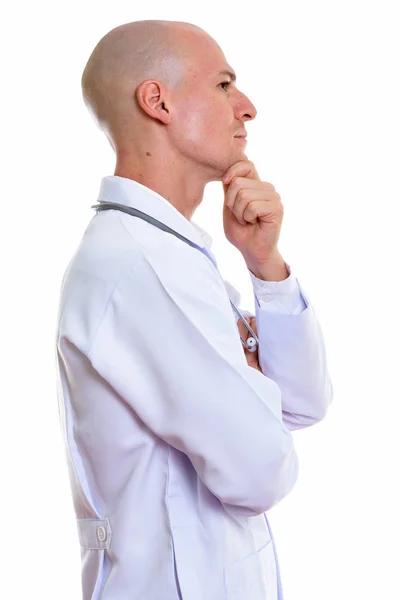 Profile view of young handsome bald man doctor thinking — Stock Photo, Image