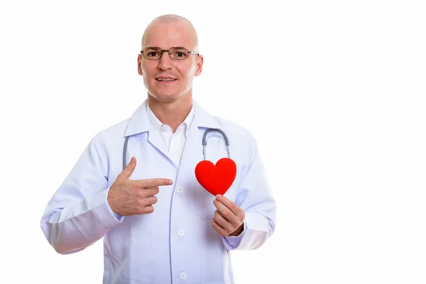 Estudio disparo de joven hombre calvo feliz médico sonriendo mientras sostiene —  Fotos de Stock