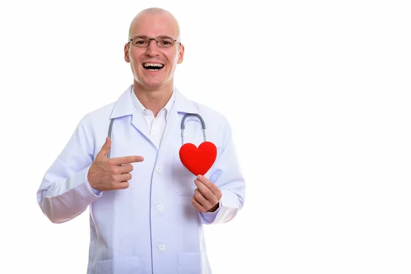 Joven hombre calvo feliz médico sonriendo mientras sostiene y señala un —  Fotos de Stock