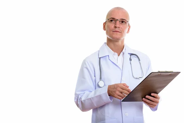 Estúdio tiro de jovem bonito homem careca médico segurando prancheta — Fotografia de Stock