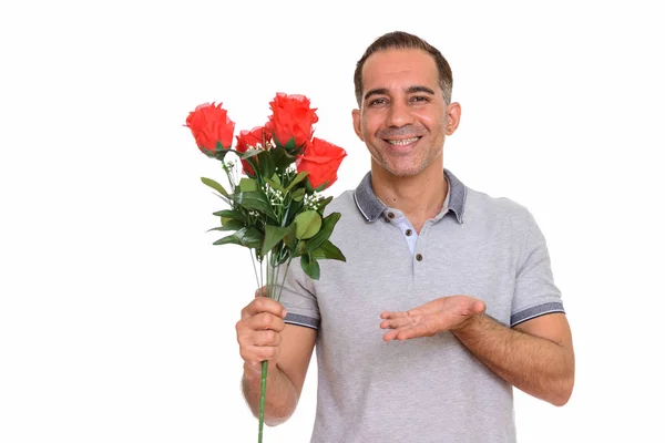 Зрелый счастливый персидский мужчина с красными розами — стоковое фото
