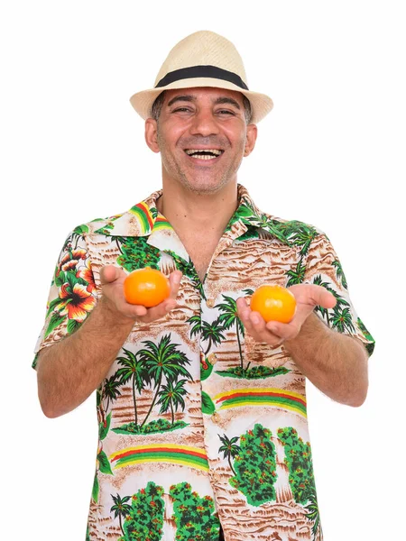 Maturo felice uomo persiano pronto per la vacanza in possesso di due arance — Foto Stock