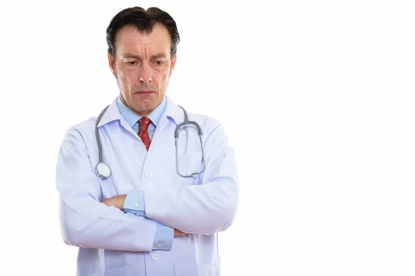 Studio shot of mature handsome man doctor thinking while looking — Stock Photo, Image