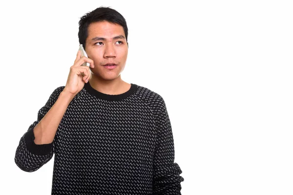 Estudio disparo de joven asiático hombre hablando en el teléfono móvil mientras thi — Foto de Stock