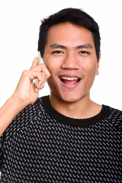 Gezicht van jonge gelukkig Aziatische man die lacht tijdens het gesprek op mobiele ph — Stockfoto