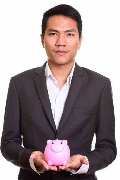 Close up of young Asian businessman holding piggy bank — Stock Photo, Image