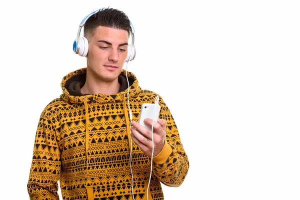 Captura de estudio de un joven guapo escuchando música mientras usa —  Fotos de Stock