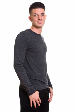 Genç ve yakışıklı adamın ayakta durduğu bir stüdyo fotoğrafı.