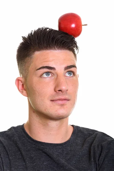 Studio shot de jeune homme beau avec pomme rouge sur la tête — Photo