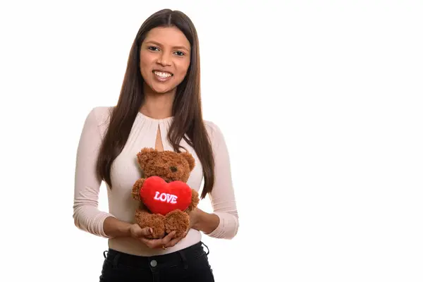 Молодая счастливая бразильская женщина улыбается, держа в руках остроумие плюшевого медведя — стоковое фото