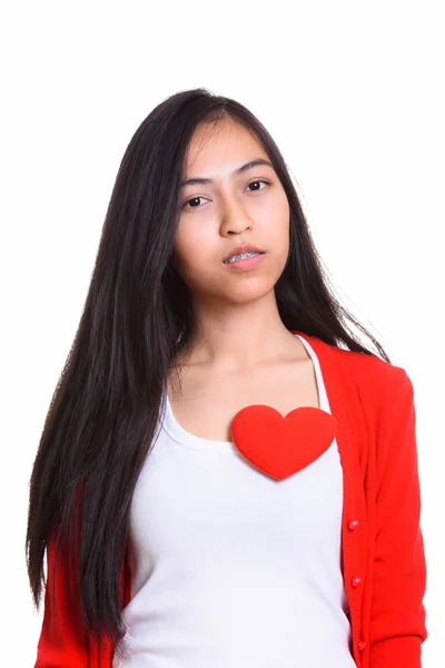 Studio colpo di giovane asiatica adolescente con cuore rosso sul petto — Foto Stock