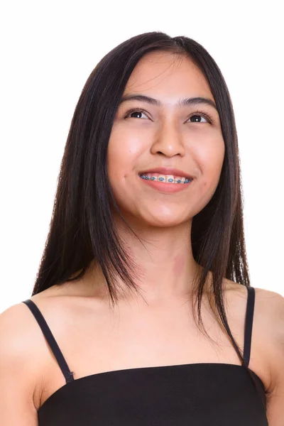 Cara de joven feliz Asiática adolescente sonriendo mientras piensa —  Fotos de Stock