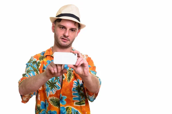 Studio shot of young man looking bored while taking picture with — Stock Photo, Image