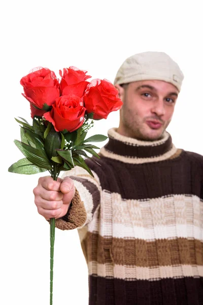 赤いバラにフォーカスを持つ赤いバラを与える若い男のスタジオ撮影 — ストック写真
