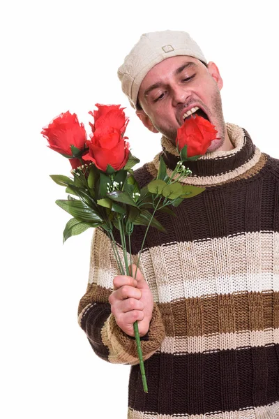 Plan studio d'un jeune homme mangeant des roses rouges — Photo