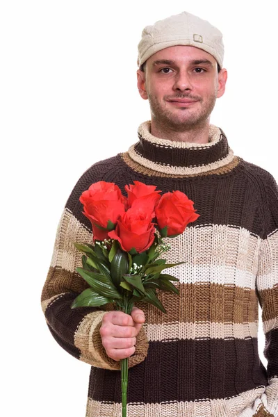 Estudio de un joven sosteniendo rosas rojas —  Fotos de Stock