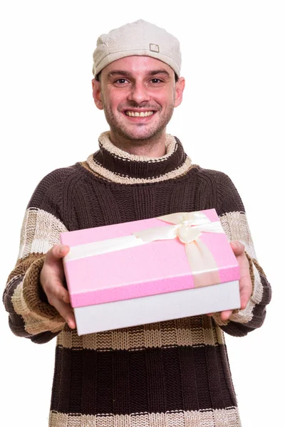 उपहार बॉक्स देने के दौरान मुस्कुराते हुए युवा खुश आदमी का स्टूडियो शॉट — स्टॉक फ़ोटो, इमेज