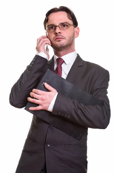 Продуманий молодий бізнесмен розмовляє по мобільному телефону в той час як Holdi — стокове фото
