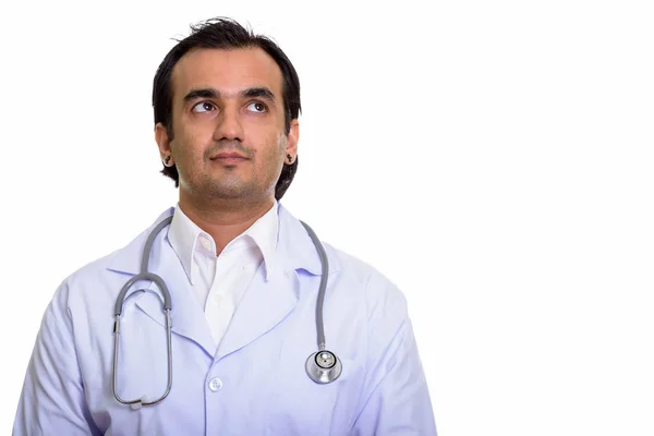 Studio shot of Persian man doctor thinking while looking up — Stock Photo, Image