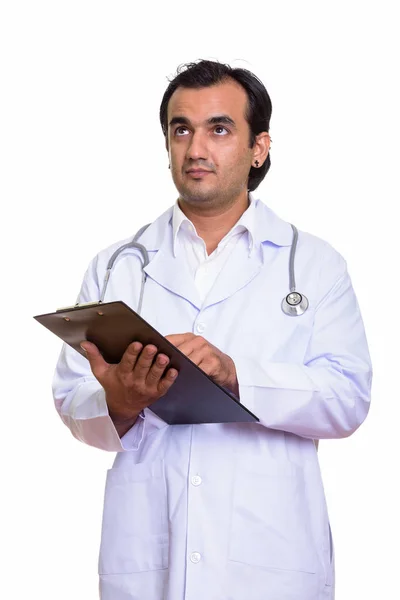 Captura de estudio del médico persa sosteniendo el portapapeles mientras piensa — Foto de Stock