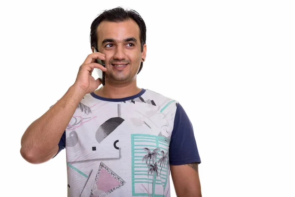 Studio shot of happy Persian man smiling and talking on mobile p — Stock Photo, Image