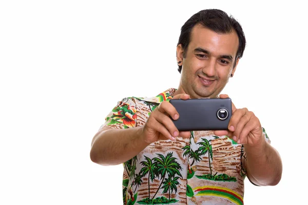 Studio shot of happy Persian man smiling while taking picture wi — Stock Photo, Image