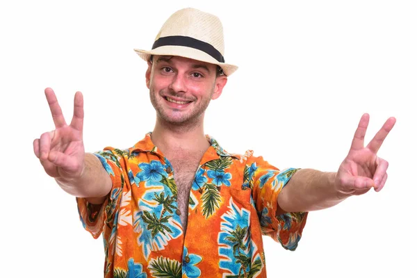 Studio shot of young happy man smiling while giving peace sign w Stock Image