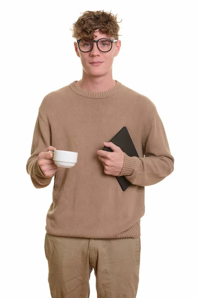 Nuori komea valkoihoinen mies, jolla on kirja ja kahvikuppi — kuvapankkivalokuva