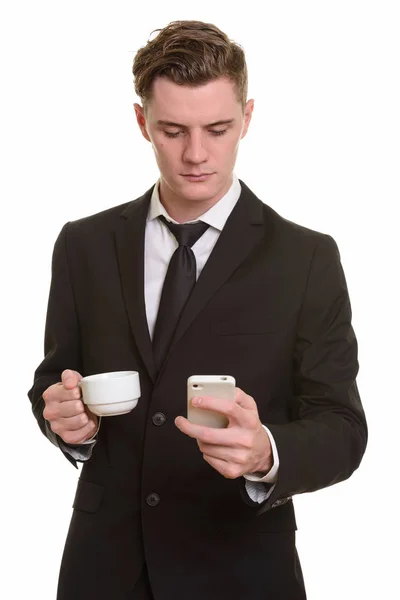 Young handsome Caucasian businessman using mobile phone while ho — Stock Photo, Image