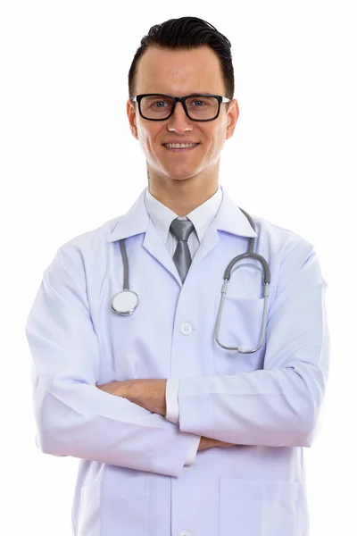 Studio shot of young happy man doctor smiling with arms crossed — Stock Photo, Image