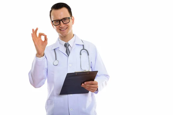 Estúdio tiro de jovem médico homem feliz sorrindo enquanto segurando clipe — Fotografia de Stock