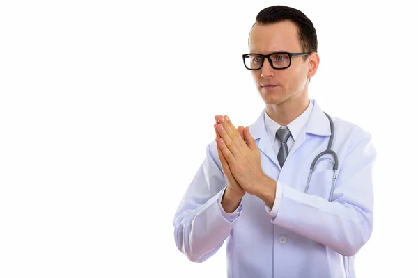 Studio shot of young handsome man doctor with hands together — Stock Photo, Image
