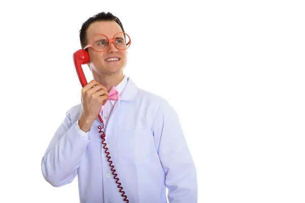 Studio shot of happy crazy man doctor smiling and thinking while — Stock Photo, Image