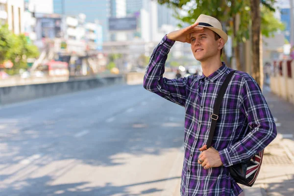 Jeune beau touriste regardant la distance tout en se tenant dans — Photo