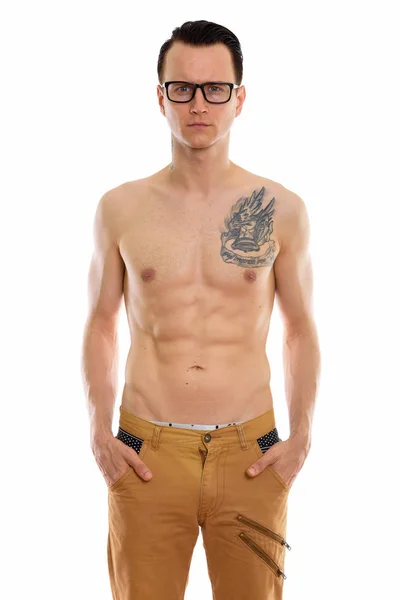 Studio shot of young handsome man standing shirtless while weari — Stock Photo, Image