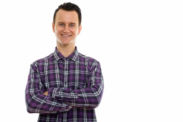 Studio shot de jeune homme heureux souriant avec les bras croisés — Photo