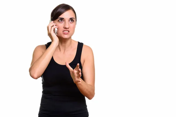 Estudio de la mujer enojada hablando en el teléfono móvil mientras piensa — Foto de Stock