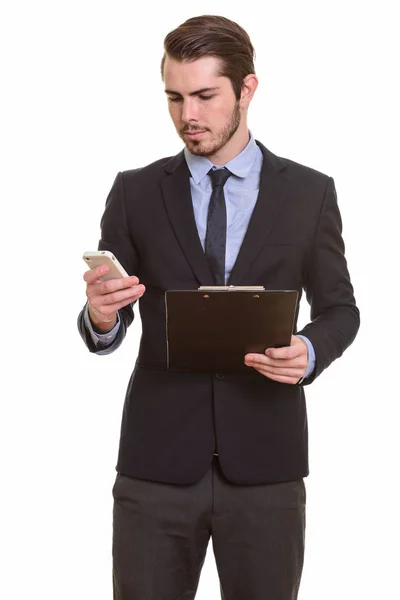 Junge hübsche kaukasische Geschäftsmann mit Handy, während ho — Stockfoto